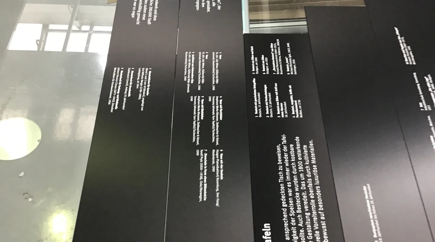 Schwarze Texttafeln aus Hartschaum an einer Glaswand im Landesmuseum Württemberg